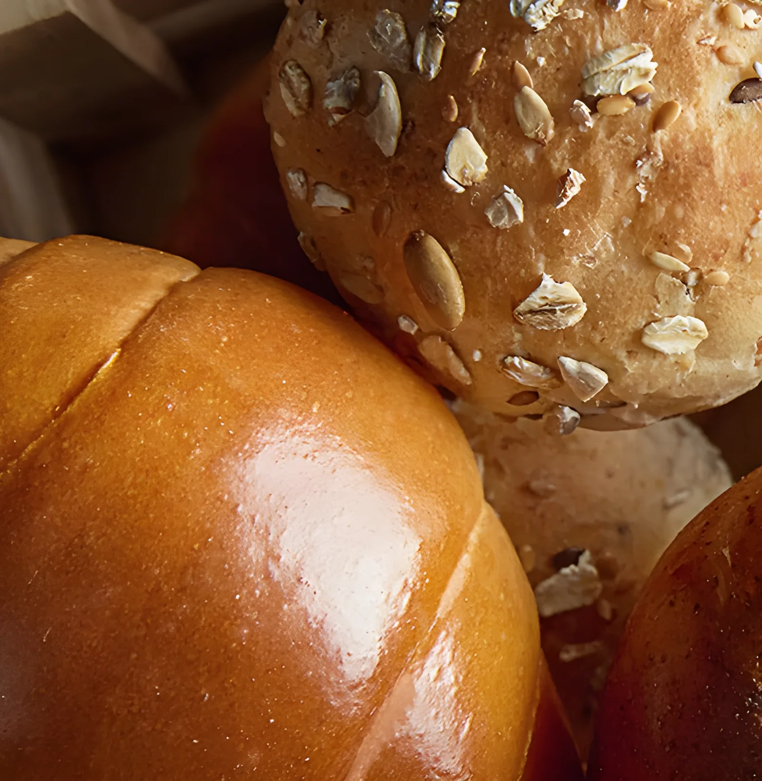 Seeded, glazed and twisted buns on a wooden board