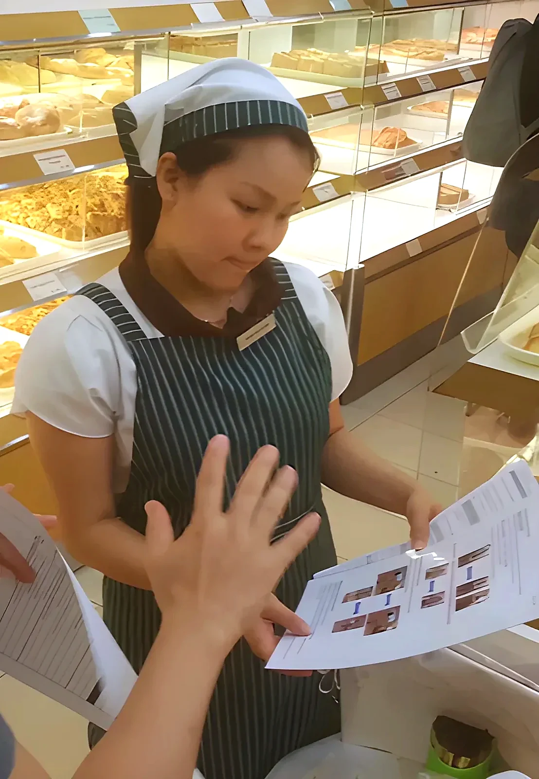 A supervisor coaching a sales assistant at the bread display