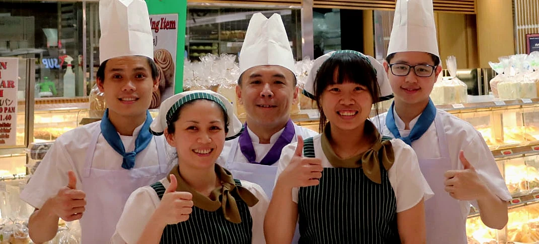 Five Four Leaves bakers and sales staff smiling at the bread counter